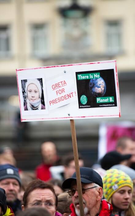 Klimaaktivist hält Schild mit Aufschrift "Greta for president" und "There is no Planet B" in einem Klimastreik in die Höhe